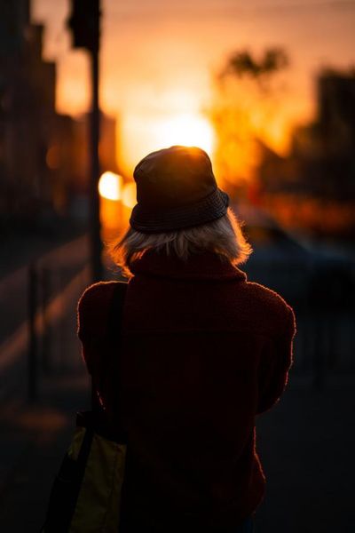 woman wearing red clothing looking at a setting sun